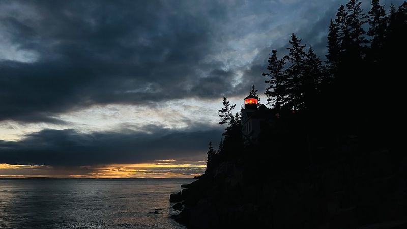 Bass Harbor Head Lighthouse glowing at dusk in Acadia